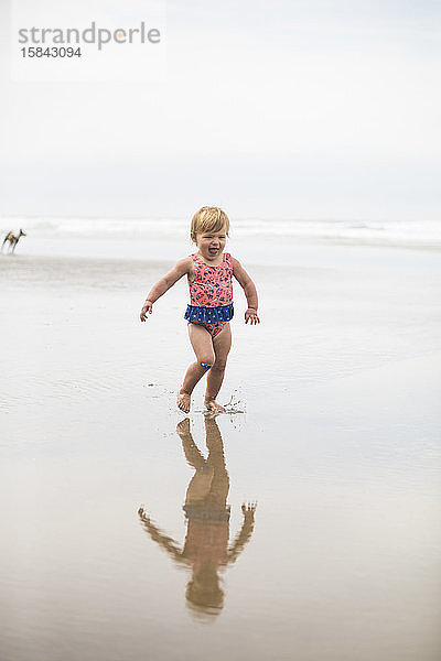 Mädchen rennt  lacht am Strand