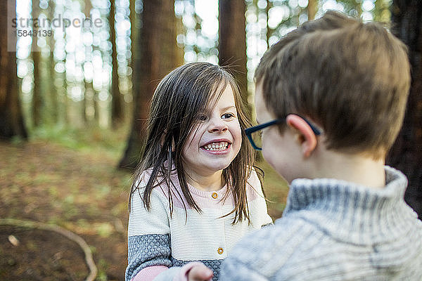Verspielte Jungen und Mädchen genießen die Zeit draußen im Wald.