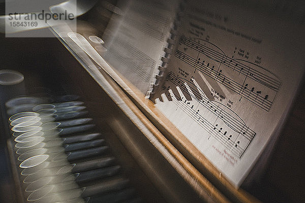 Morgensonne funkelt auf Klaviertasten mit kreativer Unschärfe der Noten