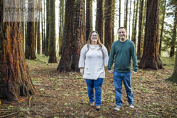 Glückliches Paar genießt Spaziergang durch einen bewaldeten Park