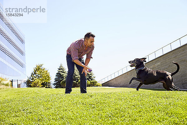 Ein Mann spielt mit seinem Hund.