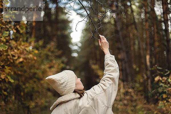 Rückenansicht einer nicht erkennbaren Frau im Wald.