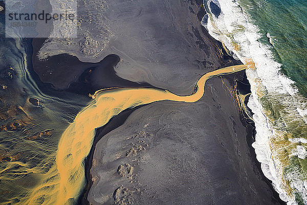 Luftaufnahme des geflochtenen orangenen Flusses  der im Süden in den Ozean mündet