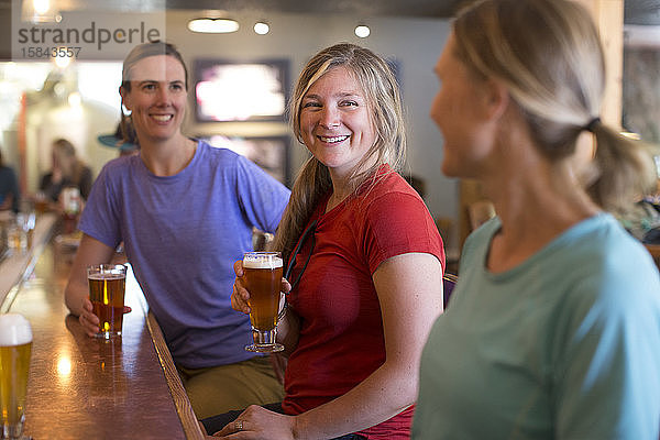 Drei Freundinnen genießen ein Bier in einer Brauerei im Regierungslager  OR.