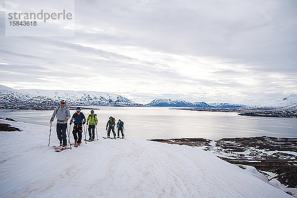 Eine Gruppe beim Skilanglauf in Island mit dem Ozean im Hintergrund