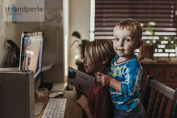 Junge Geschwister im Video-Chat am Bildschirm mit der Familie während der Isolation