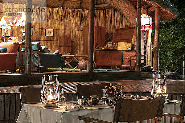 Abends ein gedeckter Tisch in einer luxuriösen Lodge  im Hintergrund ein Salon