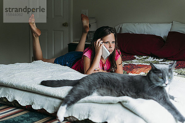 Tween Girl telefoniert in einem Schlafzimmer