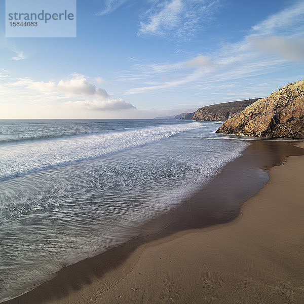 Wellen spülen über die Sandküste am Strand der isolierten Bucht von Sandwood Bay  Sutherland  Schottland