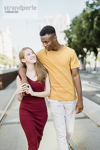 Jungen und Mädchen  die sich auf der Straße umarmen und lachen