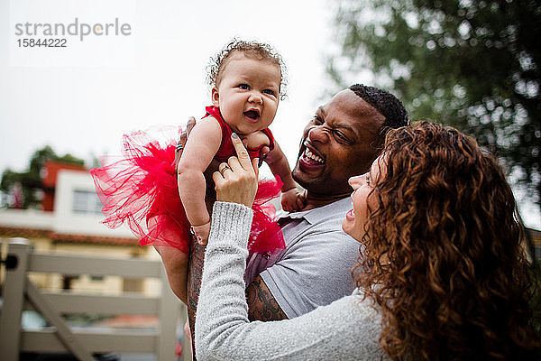 Biracial Couple Holding & Lächeln auf Baby