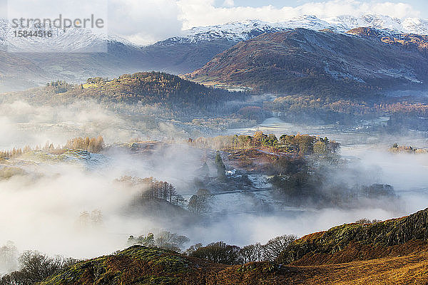 Blick hinunter in das Langdale-Tal oberhalb des durch eine Temperaturinversion gebildeten Talnebels auf Loughrigg  nahe Ambleside im Lake District National Park.