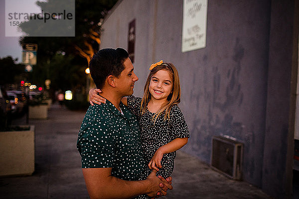 Vater betrachtet Tochter als Tochter lächelt für die Kamera
