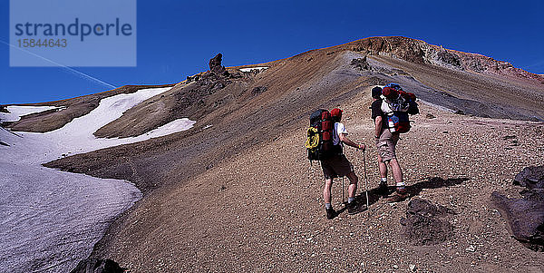 zwei Wanderer  die einen Berg in Landmannalaugar besteigen