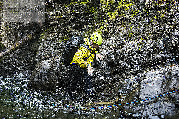 Backpacker wandert durch eine Flussschlucht.