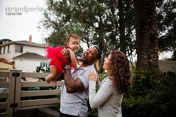 Biracial Couple Holding & Lächeln auf Baby