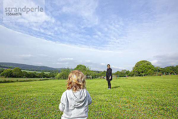ein kleiner Junge und seine Mutter amüsieren sich auf einer grünen Wiese auf dem Land  Caurel Bretagne  Frankreich.