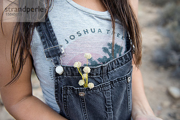 Eine Frau pflückt Blumen am Straßenrand in Joshua Tree.