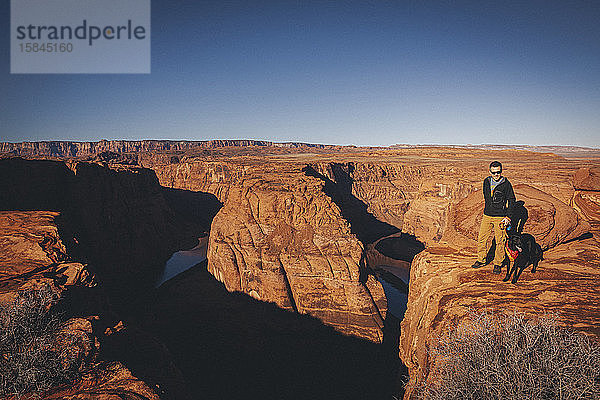 Ein Mann mit einem Hund steht in der Nähe von Horseshoe Bend  Arizona