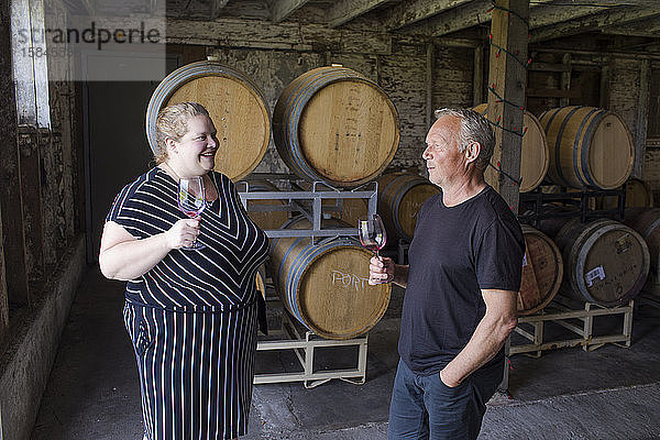 Mann und Frau unterhalten sich während einer Weinverkostung auf einem örtlichen Weingut.