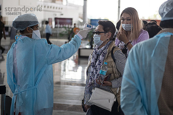 Gesundheitspersonal untersucht am Flughafen Khajuraho  Madhya Pradesh  Indien  asiatische Passagiere auf mögliche Symptome des Coronavirus.