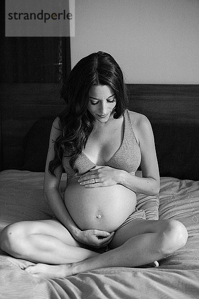 Schwangere Frau im Bett schwarz-weiß