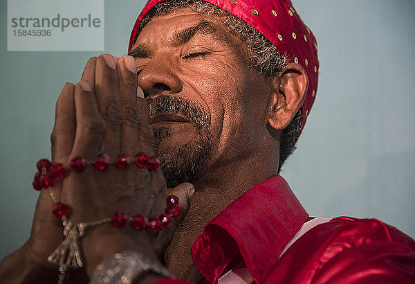 Afro-brasilianischer Mann betet während religiöser Karnevalsfeier