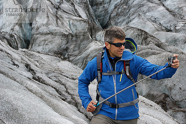 Ein Mann und eine Aktion mit einer Kamera auf dem Skaftafell-Gletscher in Vatnajokull