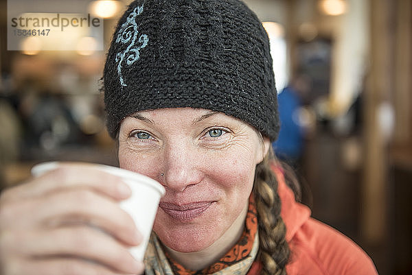 Eine Frau genießt eine Tasse Tee in einer Lodge im Skigebiet von Mount Baker.