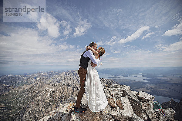 Das frisch verheiratete Paar teilt den ersten Kuss auf dem Gipfel des Grand Teton Wyoming