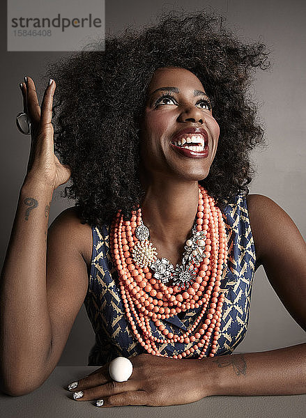 Lächelnde afroamerikanische erwachsene Frau Studio-Portrait auf grauem Hintergrund