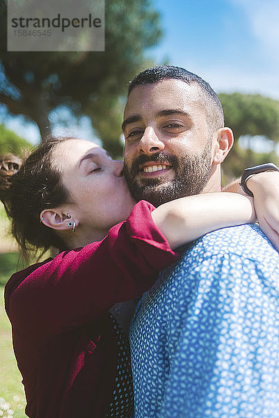 Glückliches Paar küsst und umarmt sich im Park