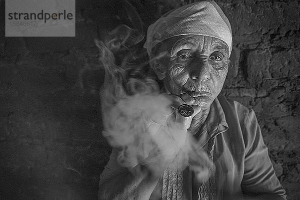 Alte Frau raucht Pfeife in ihrem Haus im Norden Brasiliens