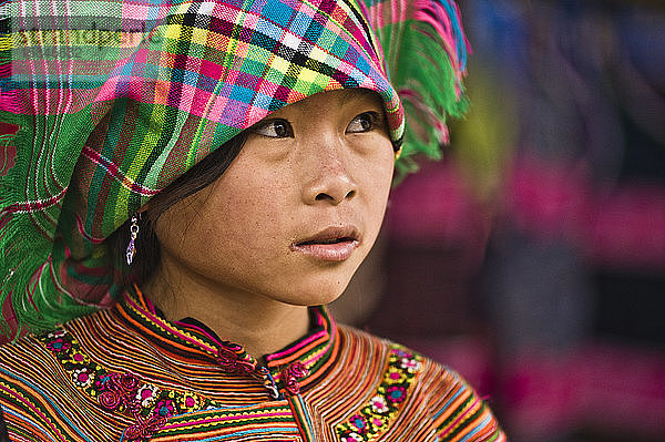 Mädchen auf dem Markt von Bac Ha mit bunt bestickter Kleidung und Kopftuch