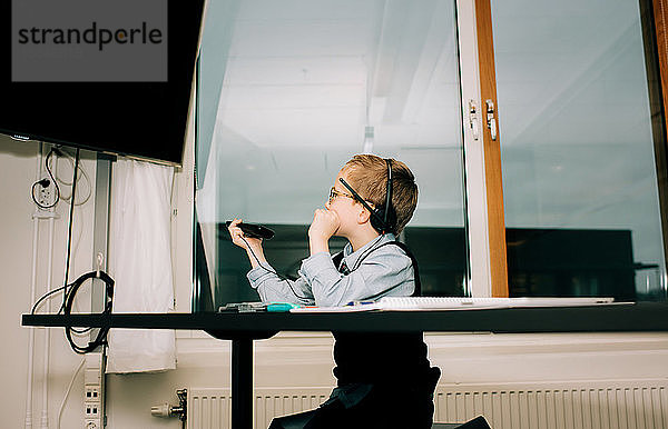 Junge hilft seinem Vater bei einer Präsentation bei der Arbeit in seinem Büro