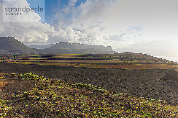 Landschaft schwarzer Vulkanberg mit blauem Himmel