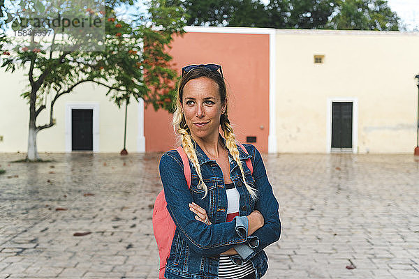 Fröhliche Touristin auf der Altstadtstraße von Valladolid an einem regnerischen Tag