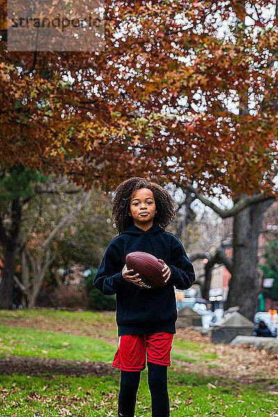 Porträt eines selbstbewussten Mädchens beim Training von American Football im Stadtpark