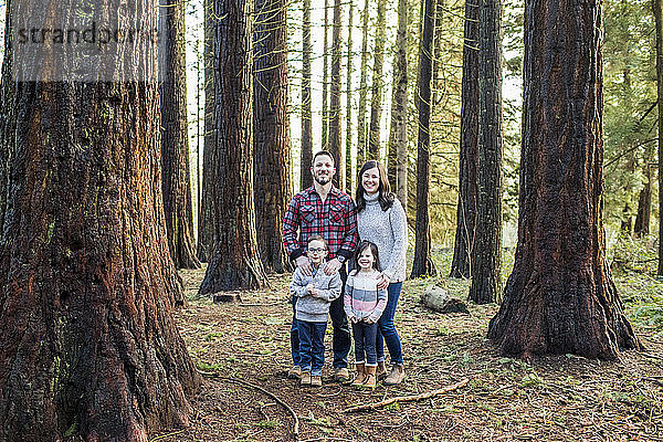 Porträt einer attraktiven Familie im Wald.