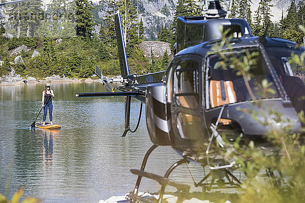Paddelbretter für Frauen auf einem abgelegenen See  zu denen ein Hubschrauber Zugang hat.