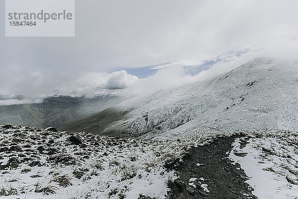 Wanderweg in Neuschnee und Wolken auf Ben Lomond  Neuseeland