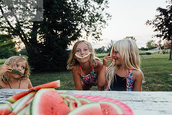 Kleine Kinder  die im Sommer beim Verzehr von Wassermelonen im Freien albern sind