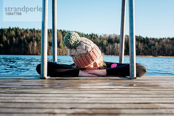 Frau entspannt sich im Winter beim Schwimmen in kaltem Eiswasser in Schweden