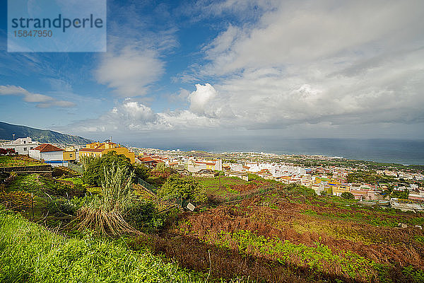 Dorf auf Teneriffa am Atlantischen Ozean mit Wolken und blauem Himmel