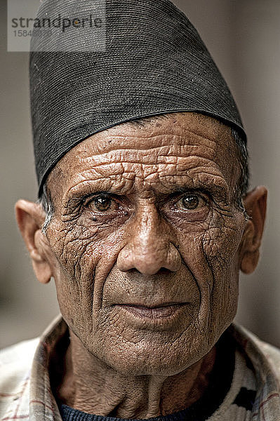 Mann trägt einen Dhaka-Topi  eine traditionelle nepalesische Mütze