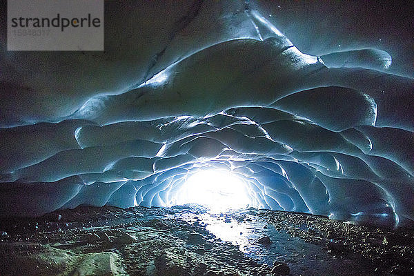 Sonnenlicht dringt in eine Gletscherhöhle ein.