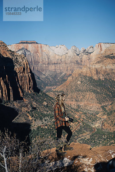 Junges Mädchen posiert mit einer Kamera mit dem Zion-Nationalpark als Hintergrund