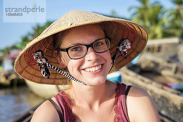 Junger kaukasischer Tourist mit vietnamesischem Kegelhut