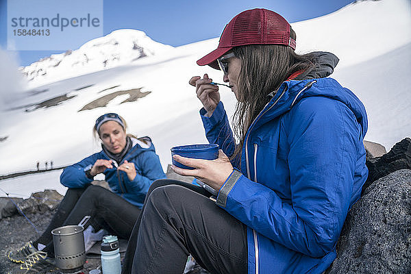Zwei Frauen frühstücken und unterhalten sich im Basislager  Mt. Baker