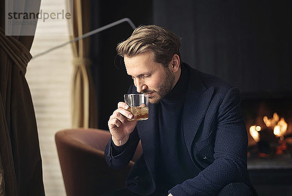 hübscher Mann trinkt einen Whisky